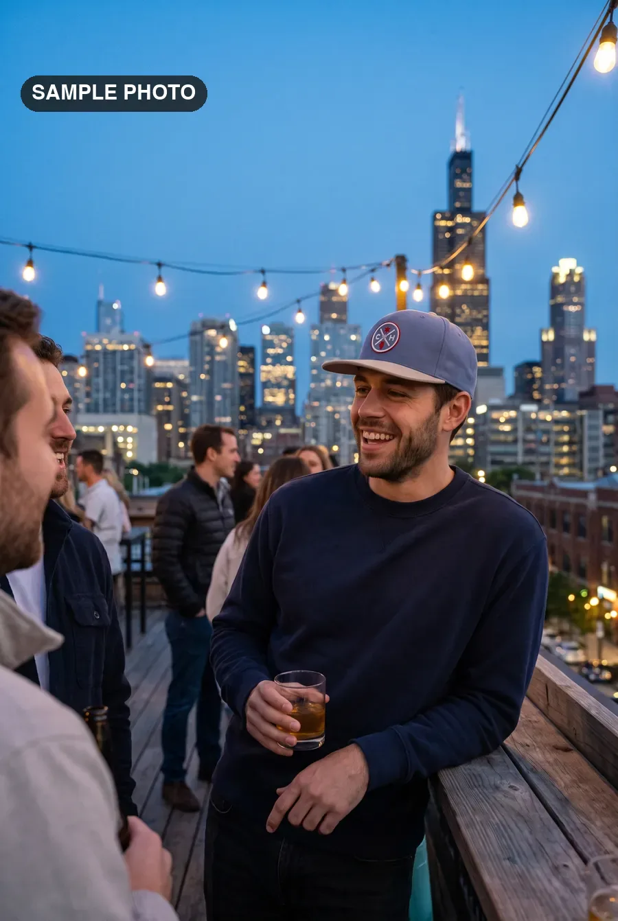 Man in a slate CH patch cap on a West Loop rooftop at dusk