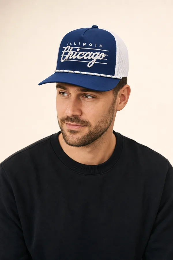 Man in a navy Chicago script cap